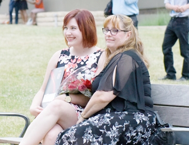 Parent and Student sitting on a bench smiling