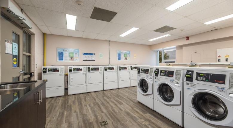 Image of the laundry room - rows of washing machines and dryers.