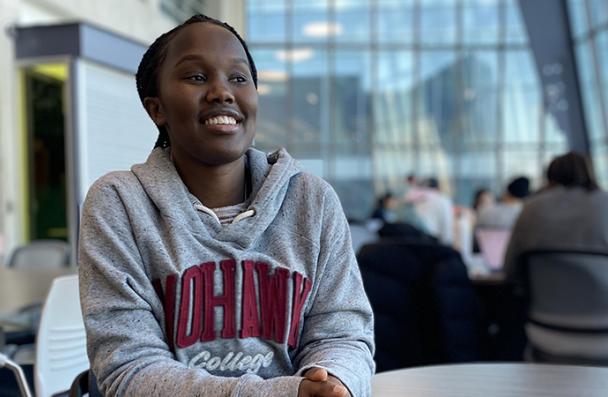 Beatrice Ingabire smiles as she sits in I-wing of the Mohawk College Fennell Campus.