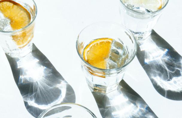 5 glasses of water with slices of oranges seen from above