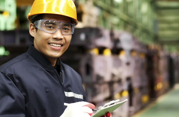 mohawk college student posting in front of machinery