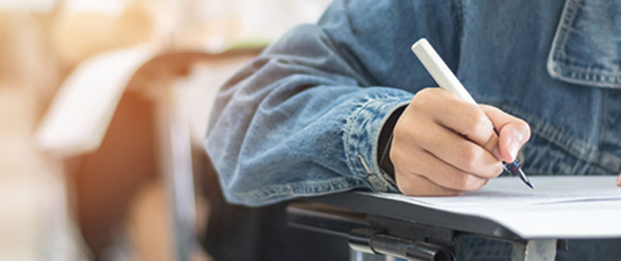 A close up image of someone writing with a pen