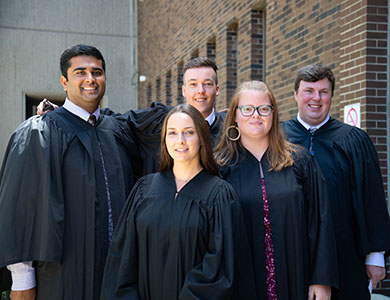 Three males and two female graduates posing for the camera on their convocation