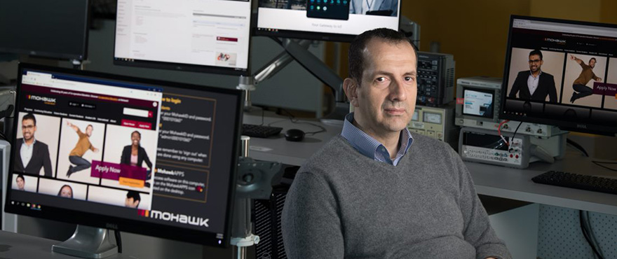 man surrounded by computers