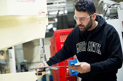 Man using metal stamping machine