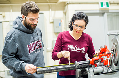 two students preparing a pipe for welding