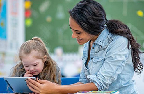 a teacher with a young child looking at a tablet
