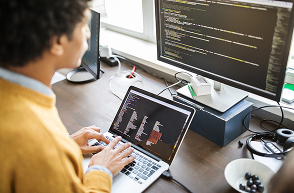 a person at a computer with two monitors