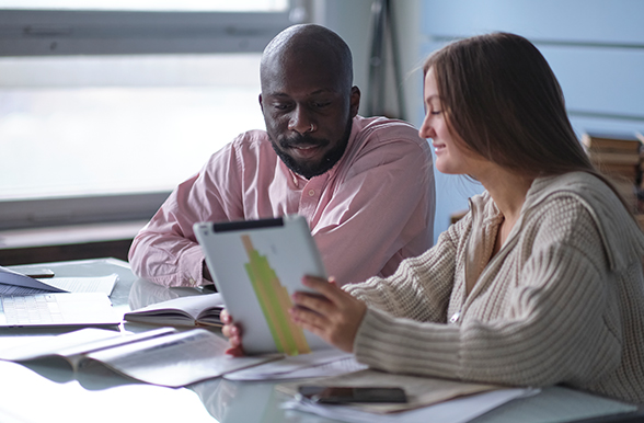 two people working together at a desk