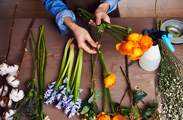 a person working with flowers on a table