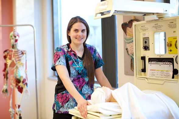 a young nurse standing by a hospital bed