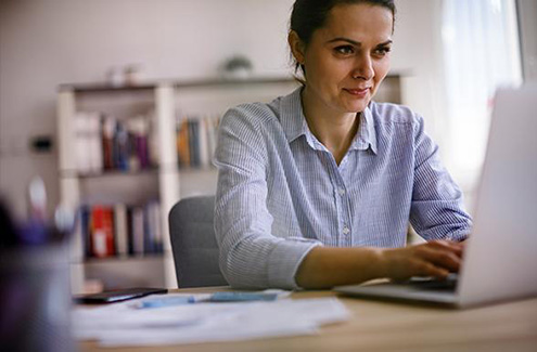 a woman at a desk working on a computer