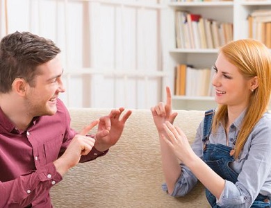 man and woman communicating using sign language