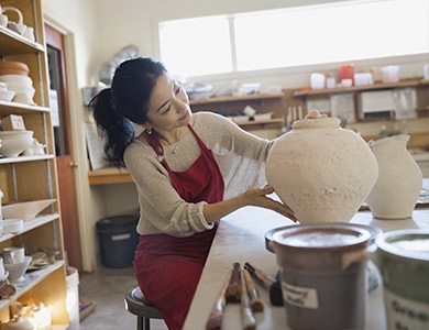 woman working on a pottery vase