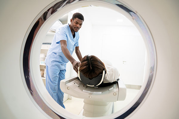Nurse helping a patient into an MRI scanner