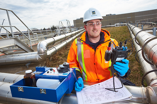 co-op student on the job checking industrial piping