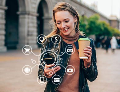 Women looking at her phone while holding a coffee cup.