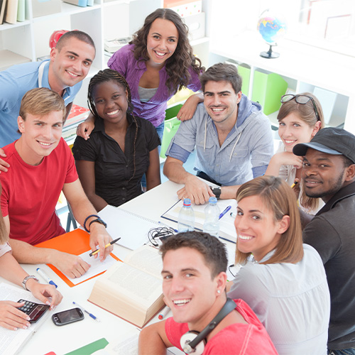 A group of students at a table with books opened.