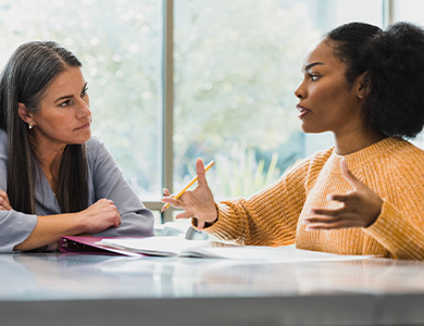 Two people talking at a table.