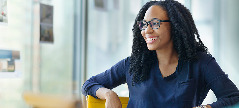 Mohawk student sitting at a desk with smile