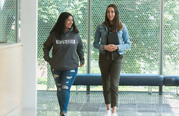 Two students walking down a hall