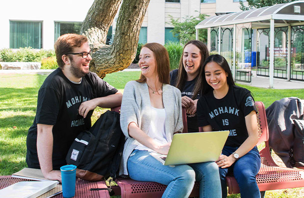 Group of students around a laptop