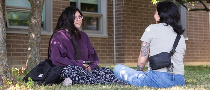 Brooke sitting on grass with a friend