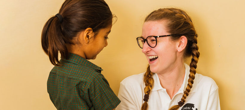 A girl is smiling at a kid