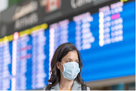 Head shot of a lady waring a mask walking in an airport