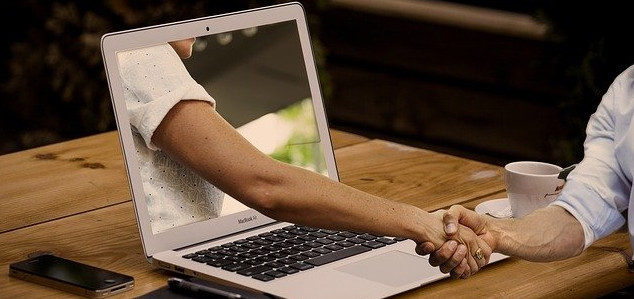 A laptop with hand reaching through.