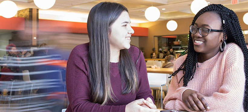 girls sitting at the food court and smiling