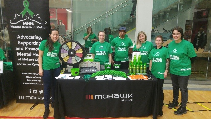 Mental Health in Motion team students offering a game and swag