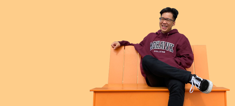 Mohawk student sitting on bench