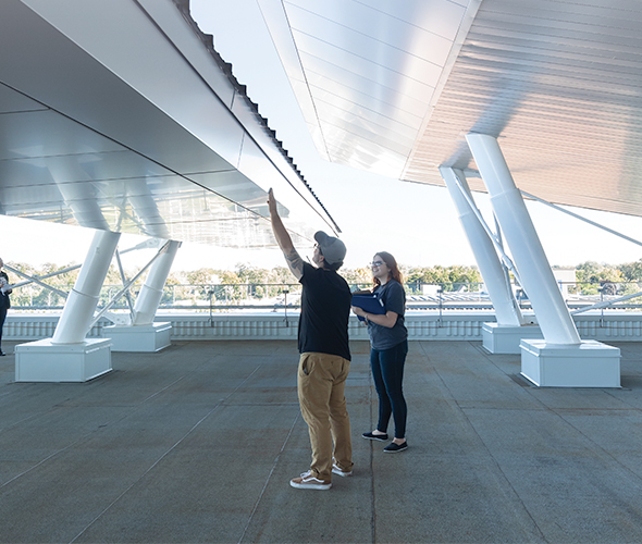 Students examine solar panels on the roof of the Joyce Centre for Partnership and Innovation