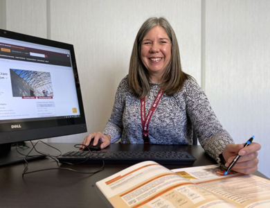 Student recruiter smiling and working on a computer