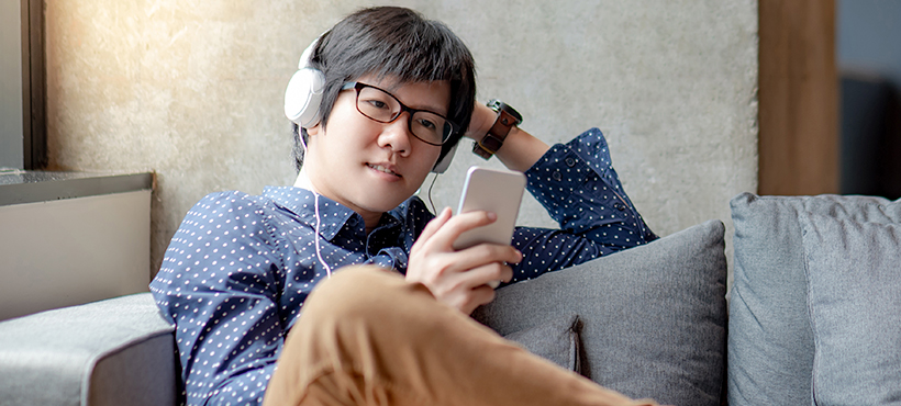 Person with headphones using their phone
