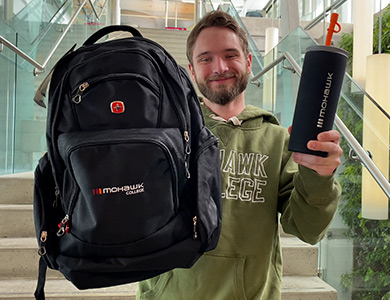 Mohawk student showing a Mohawk backpack and a Mohawk reusable water bottle.