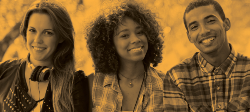 Three students sitting and smiling