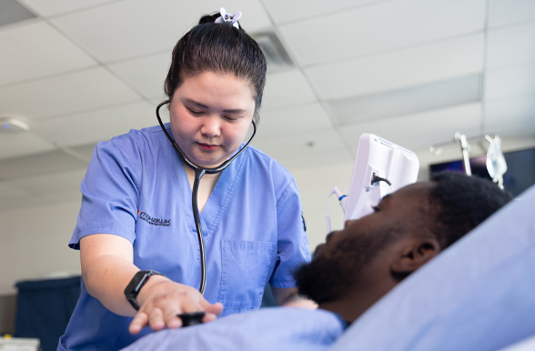 Mohawk College student listening heartbeat with stethoscope