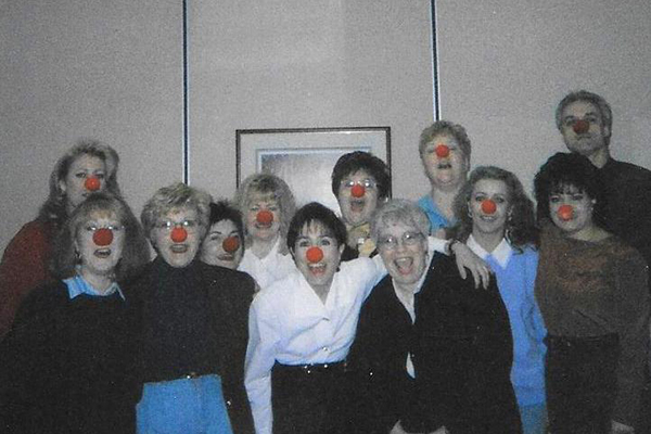 smiling members wearing a red nose