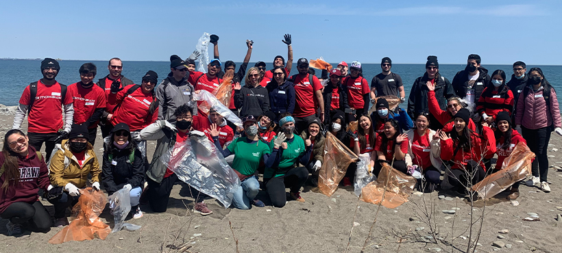 mohawk college student volunteers posing with clean up supplies on the beach
