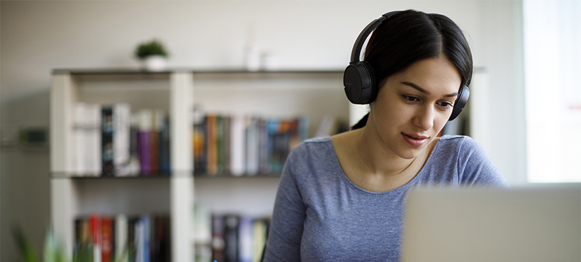 Student with headphones on computer