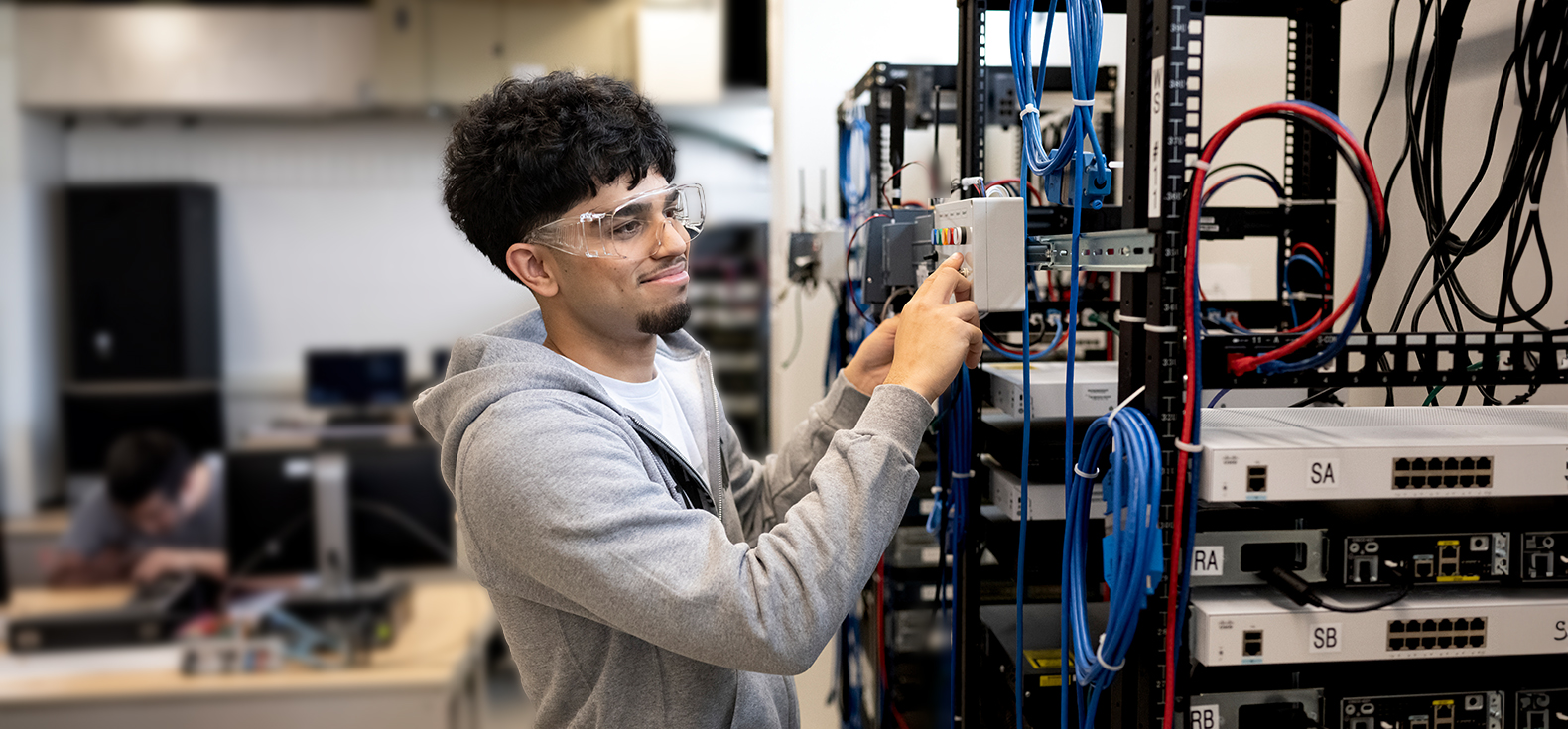  Jassi using control panel in a networking lab.