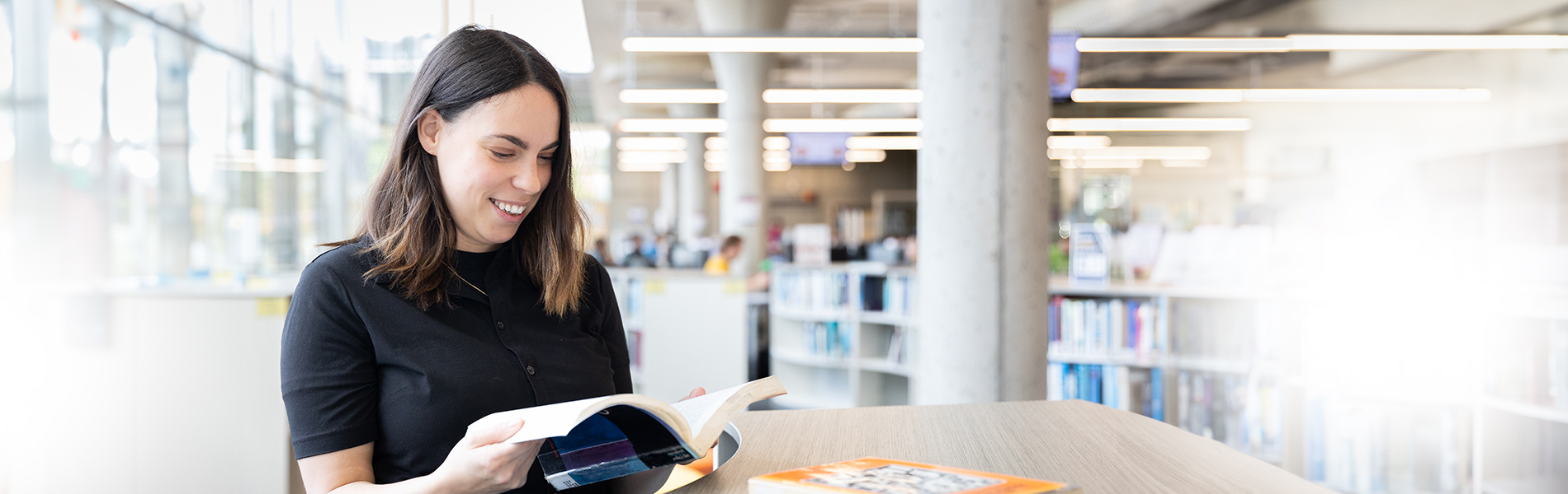 Lauren reading a book in the Mohawk College library
