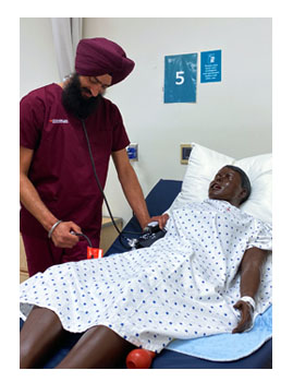 Harpreet practicing taking a patients blood pressure