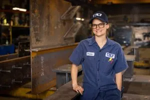 Kaylyn Roloson, wearing safety vest, working in a factory