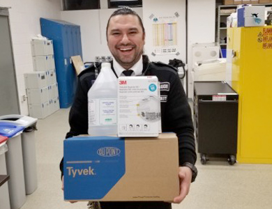 Mohawk Security smiling and carrying medical supplies to donate