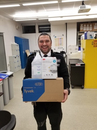 Mohawk Security smiling and holding medical equipment for donation