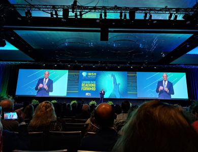 Photo from the initial plenary session with this year's IMSH President on stage, with two big digital screens positioned behind to show live video feed