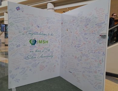 Photo of a giant 'greeting card' prop availed during the conference for attendees to sign and leave a message. Jess and Lucky signed on behalf of the CHSR on the left panel of the card